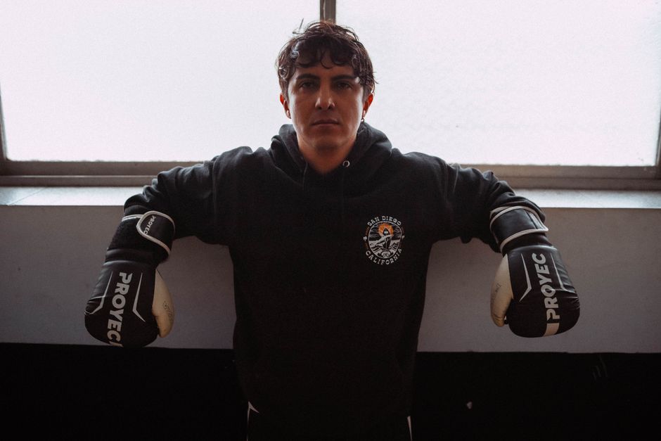 Male boxer with gloves posing in an indoor gym in Buenos Aires, Argentina.