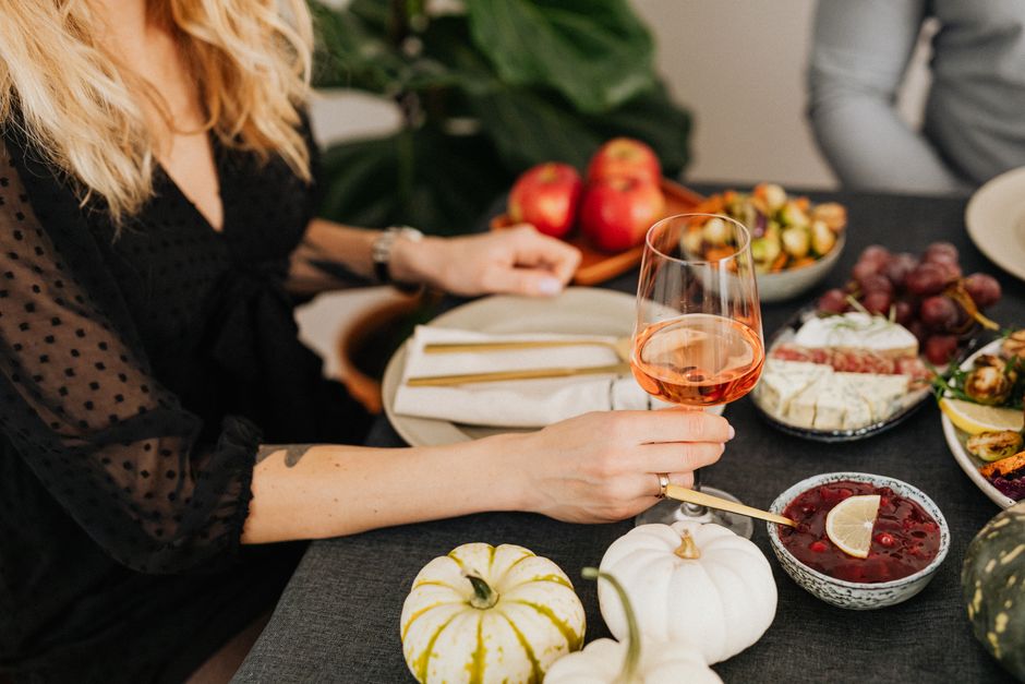 A cozy table setup featuring rosé wine, delicious appetizers, and autumn-themed decor