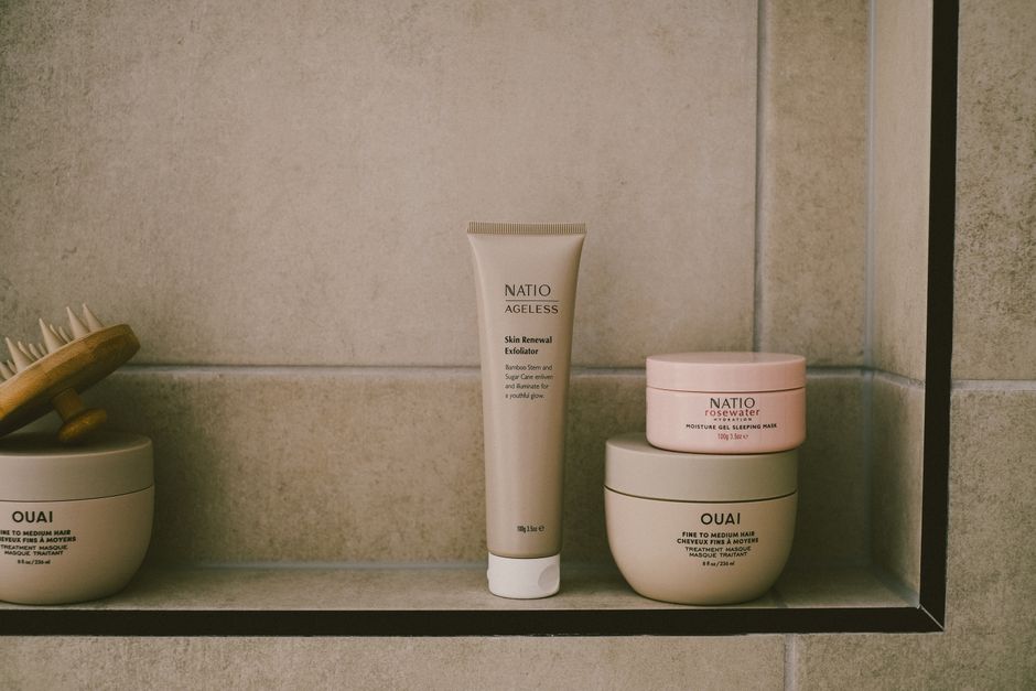 A modern bathroom shelf with self-care products in a minimalist design showcasing beige tones