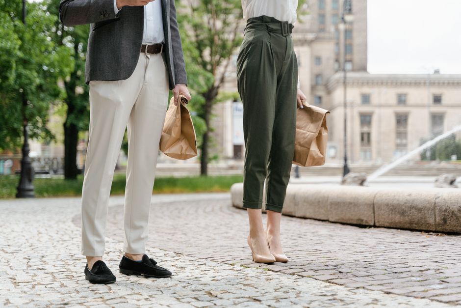 A stylish couple enjoying takeaway food in a bustling city square