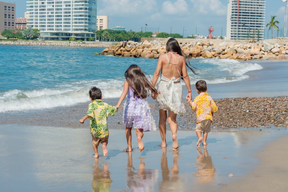 A mother with her children walking along a sunny beach, enjoying family time.