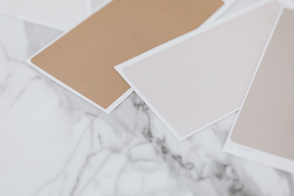 Neutral color swatches on a marble surface, ideal for design mockups.