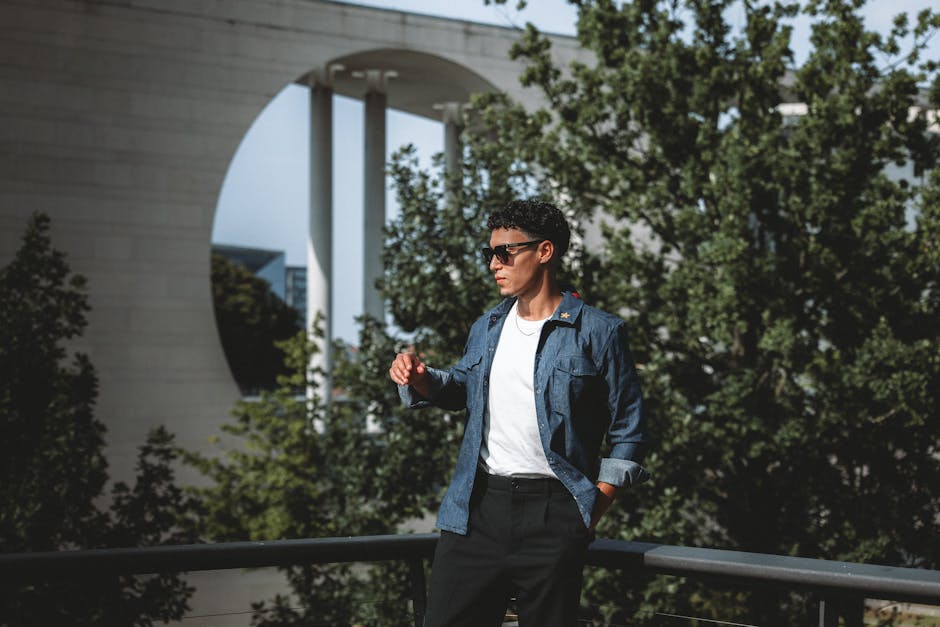 Stylish man enjoying a sunny day outdoors in Berlin, showcasing modern fashion.