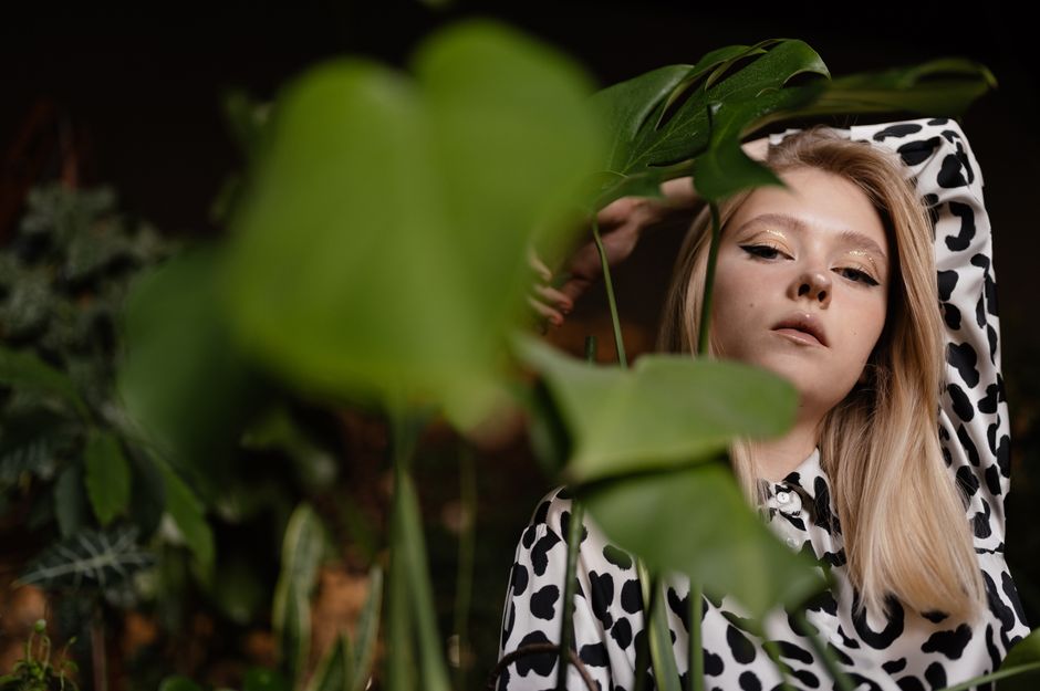 Portrait of a woman wearing leopard print surrounded by lush greenery