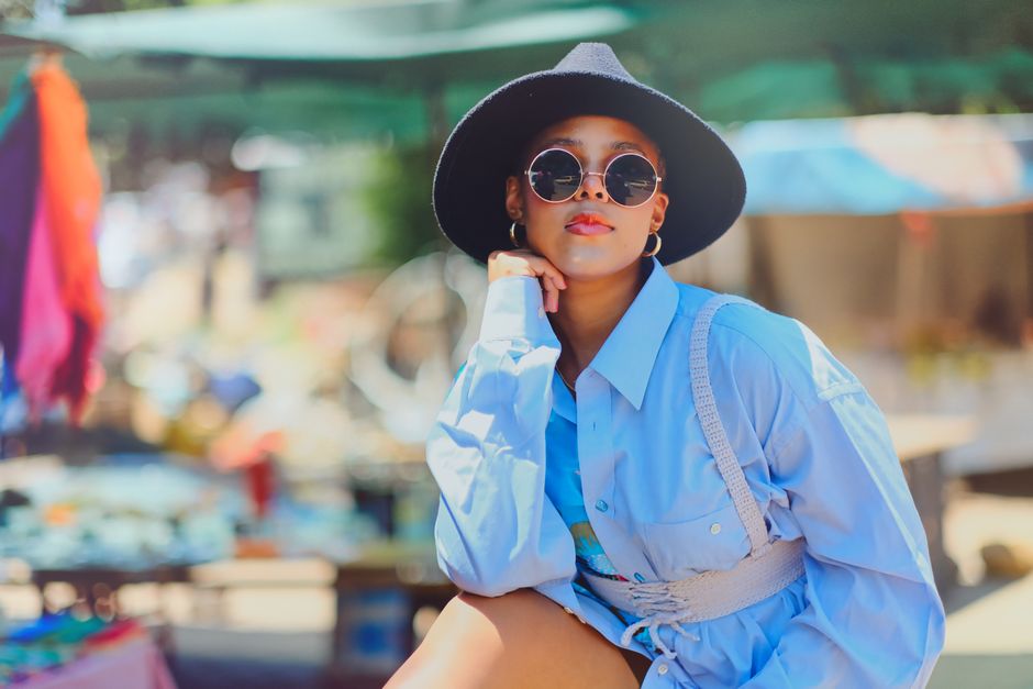 Trendy woman in stylish summer outfit and sunglasses at an outdoor market